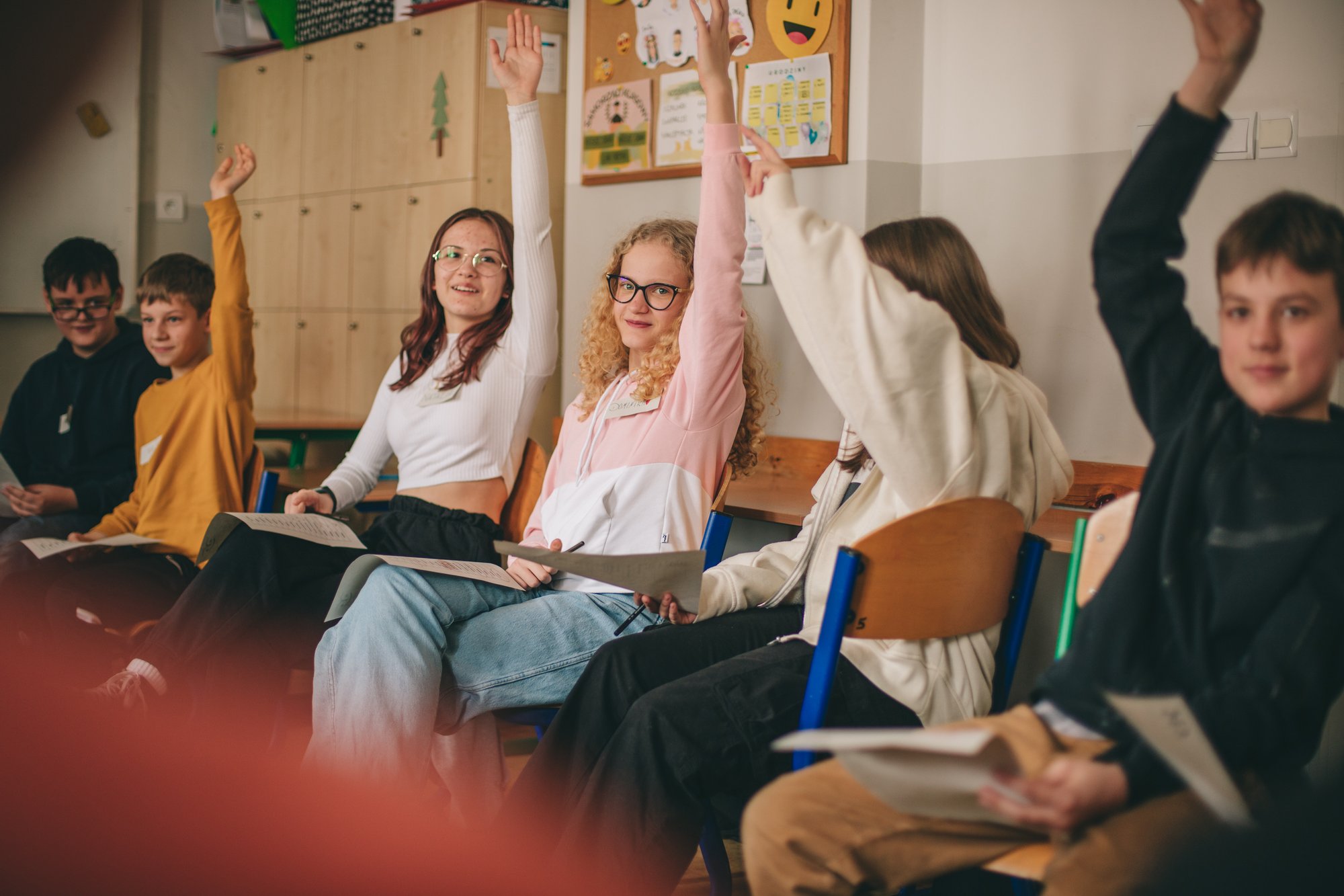 Grupa nastoletnich dzieciaków siedzi w klasie. Większość z nich się zgłasza. Trwają warsztaty.