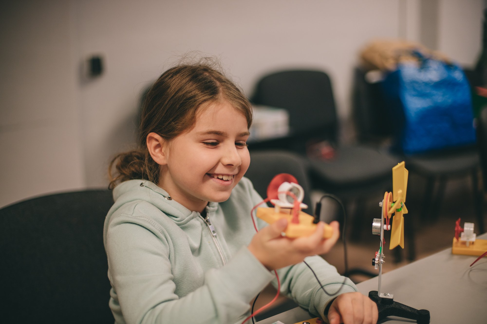 fot. Marta Sobala Uśmiechnięta dziewczynka trzymająca w rękach własnąręcznie zrobioną zabawkę.